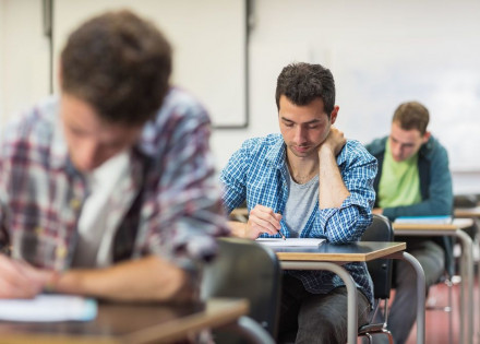 Group of young students writing notes in the classroom